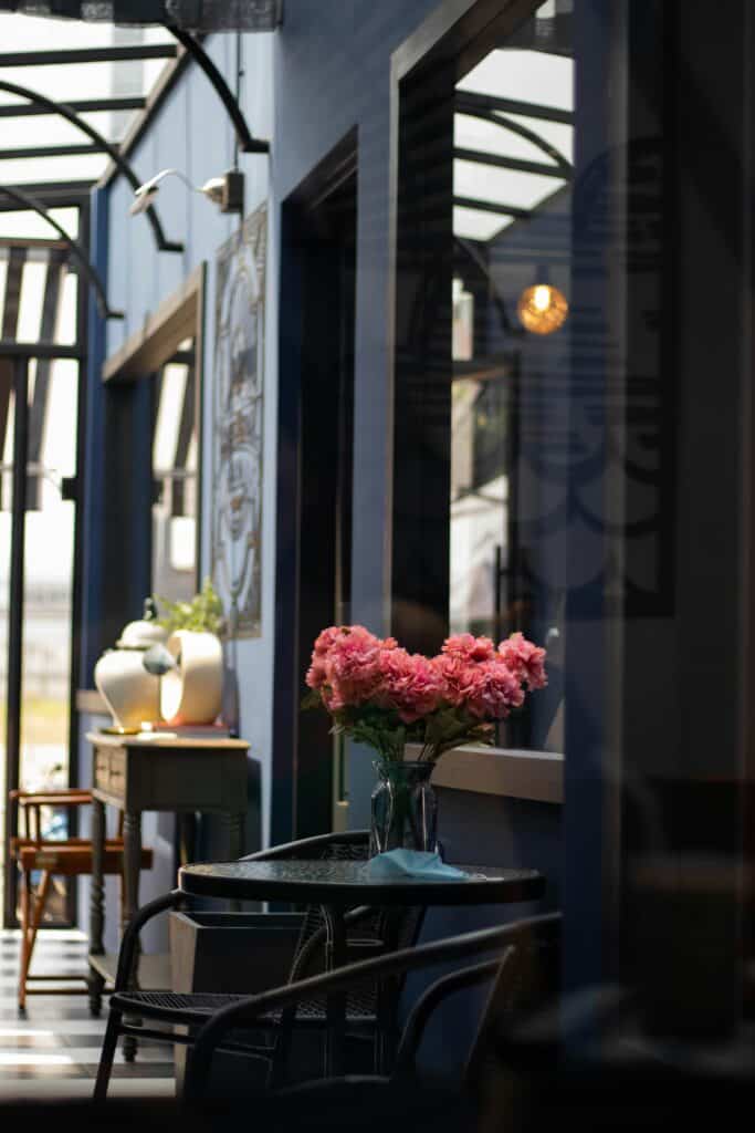Espace d'accueil dans une ambiance sombre mais lumineuse grâce à la verrière et au touche floral