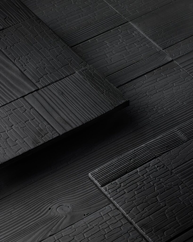 Surface minérale sombre texturée, utilisée pour structurer l’espace et renforcer la perception de profondeur et de confort.