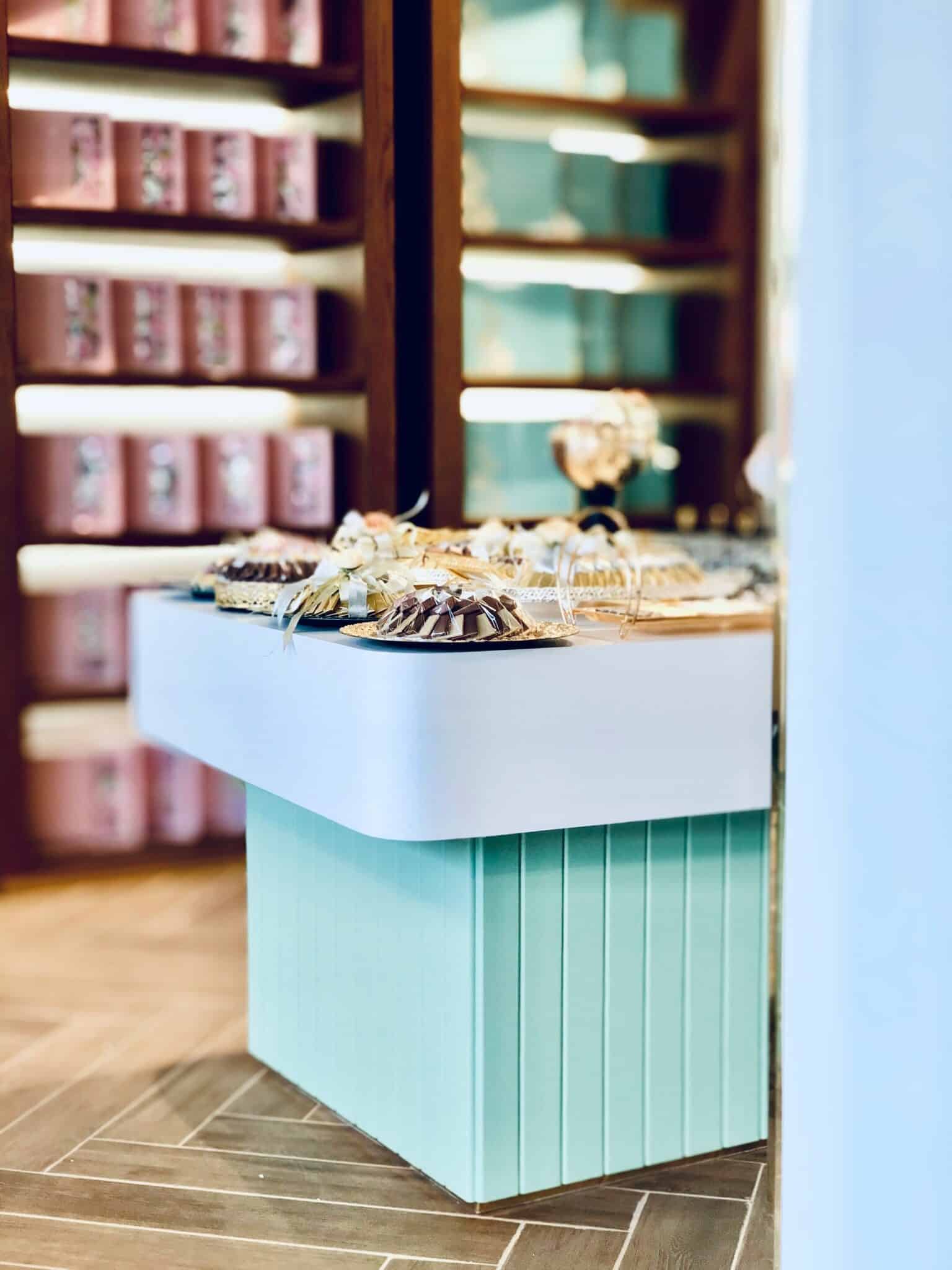 Comptoir central dans une épicerie fine avec mise en scène de produits gourmands et éclairage d'ambiance.