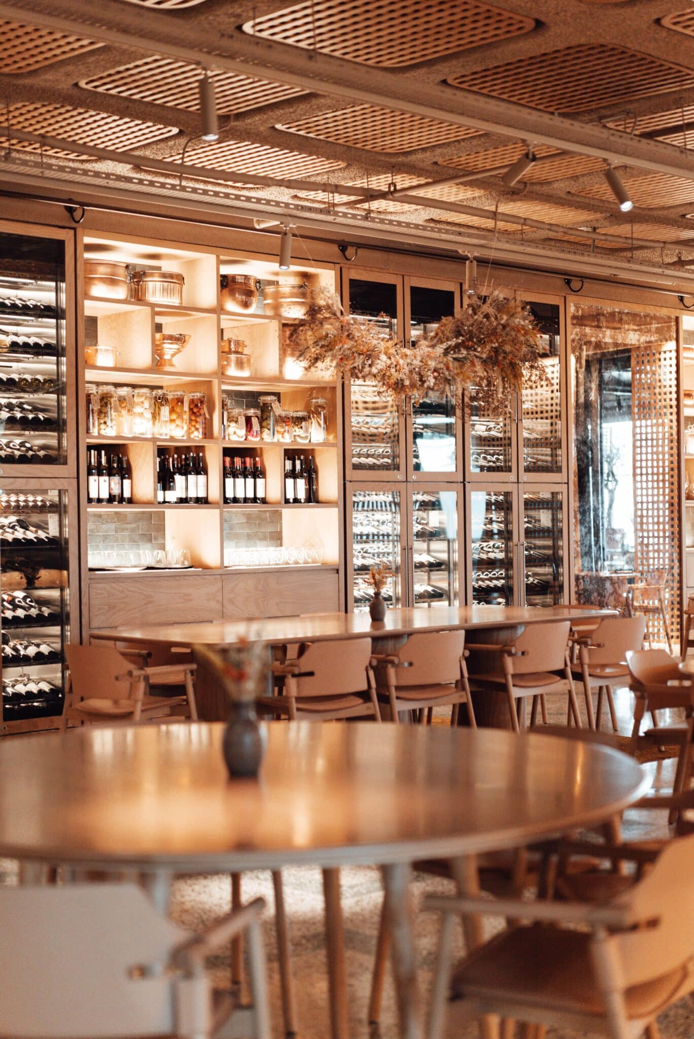 Espace dégustation et cave à vins intégrés dans une épicerie fine au design chaleureux.