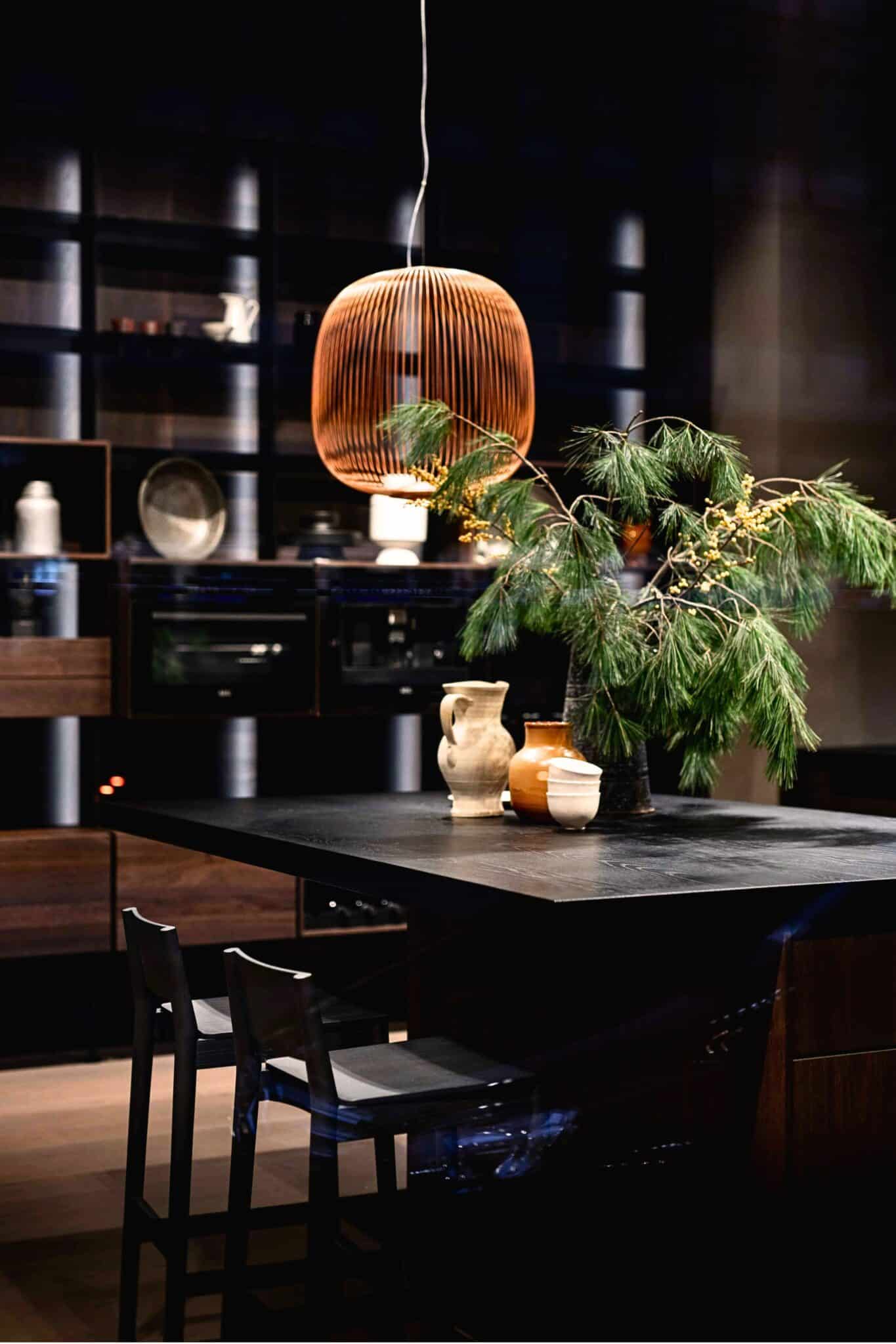 Cuisine contemporaine aux matériaux naturels mettant en valeur le bois, la lumière et une décoration épurée.