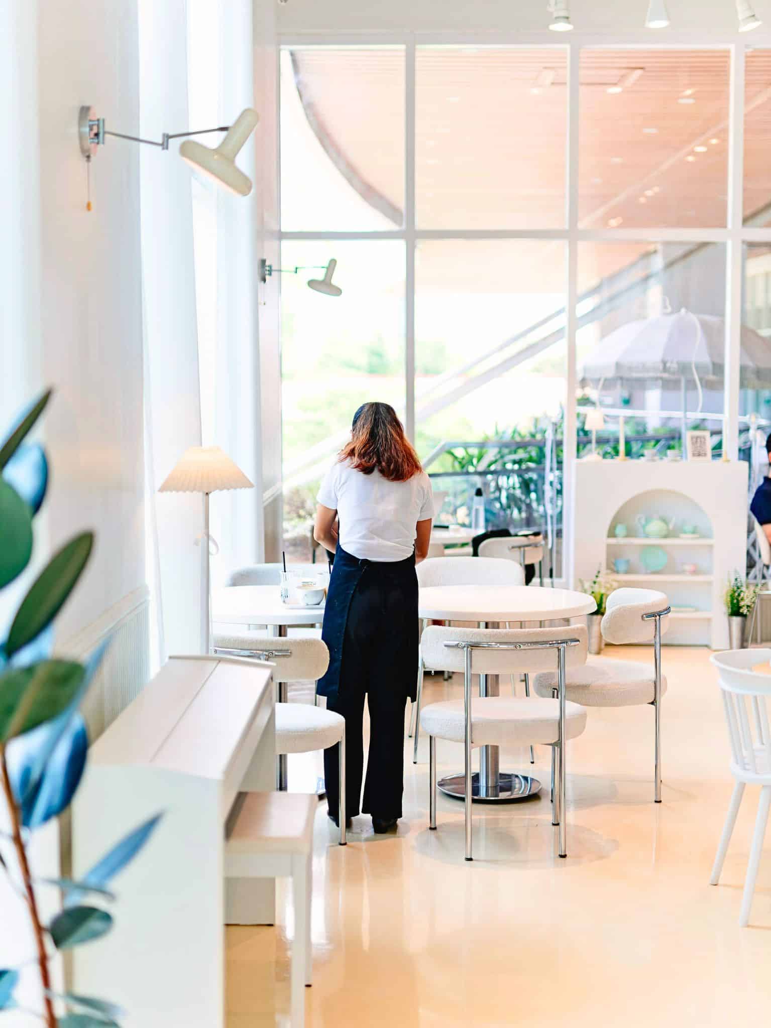 Intérieur lumineux d'un salon de thé à la décoration minimaliste favorisant une expérience client apaisante.