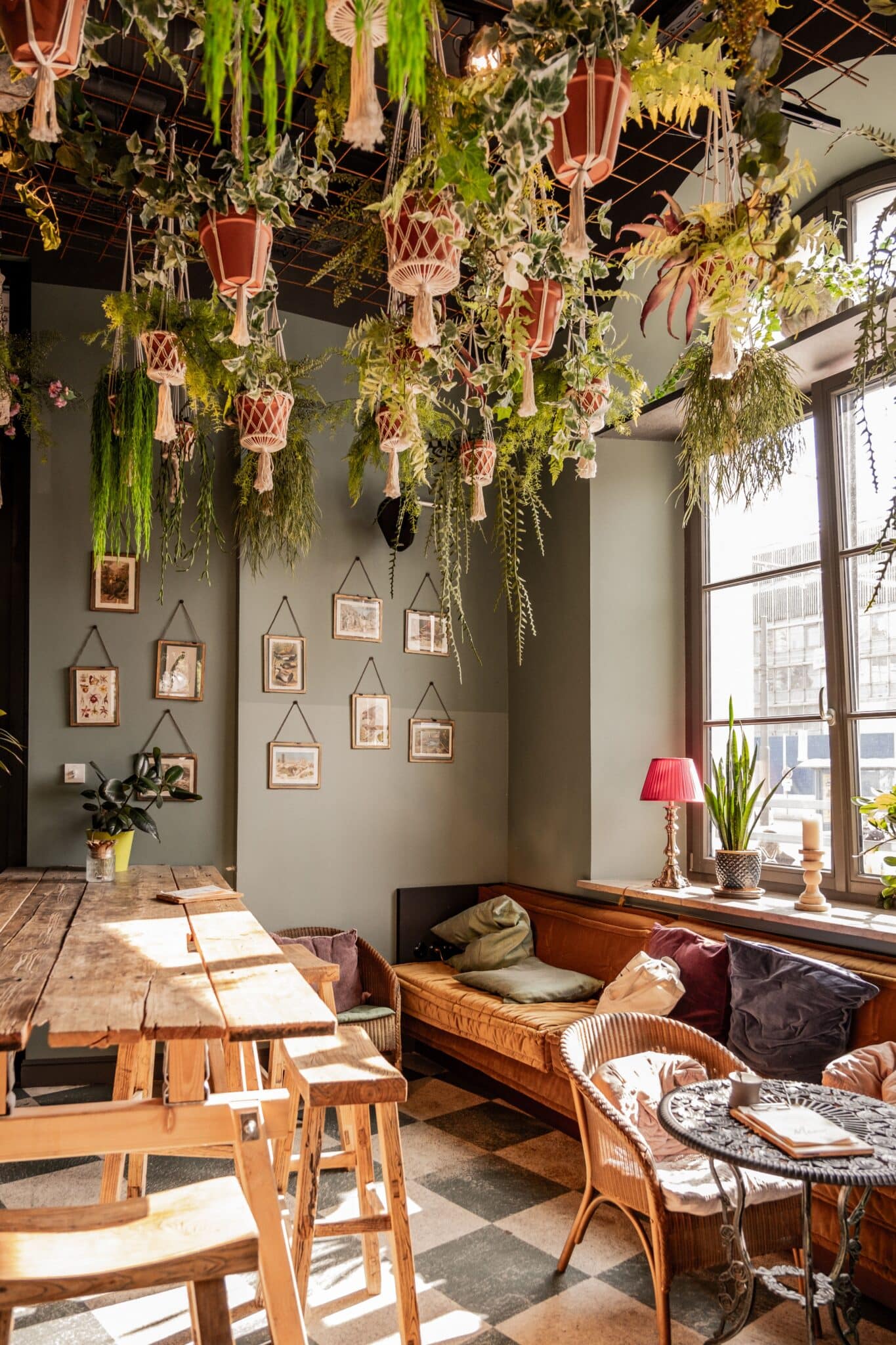 Restaurant à l'ambiance chaleureuse avec plafond végétalisé suspendu, banquettes confortables et décoration naturelle. Un exemple d'aménagement intérieur alliant identité, confort et expérience client