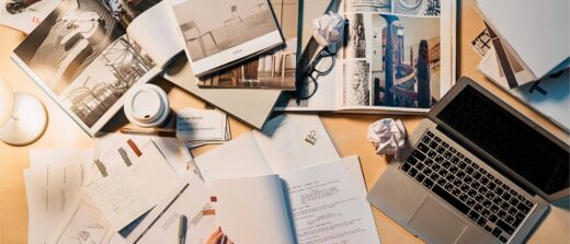Architecte d'intérieur travaillant sur la conception d'un projet d'aménagement avec maquette, plans et documents de recherche.
